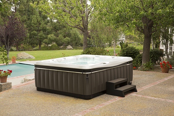 an image of a Caldera spa on a beautiful backyard patio with low maintenance and low cost