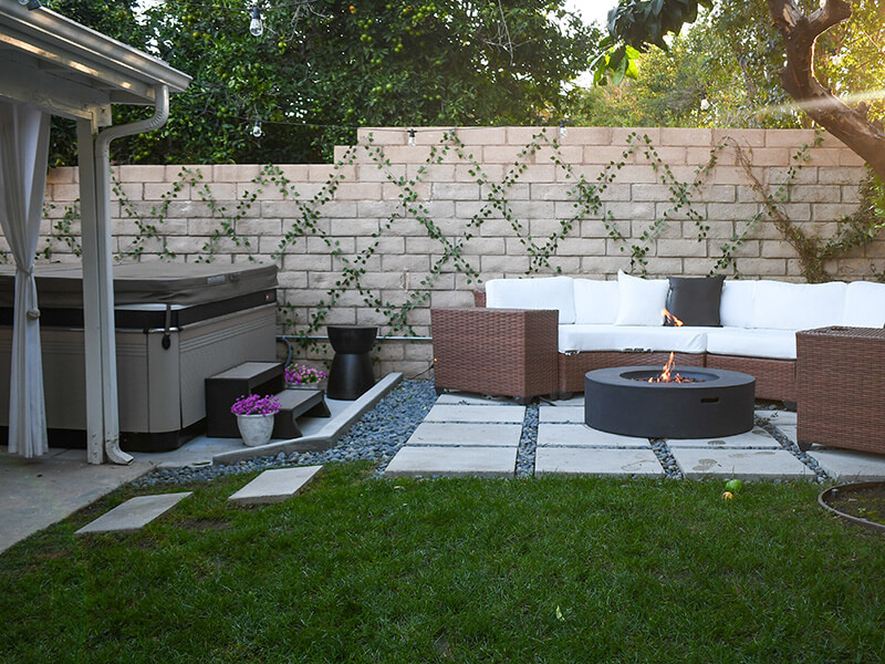 Tiana Masaniai's modern backyard with a Caldera Spa hot tub, fire pit, and patio seating.