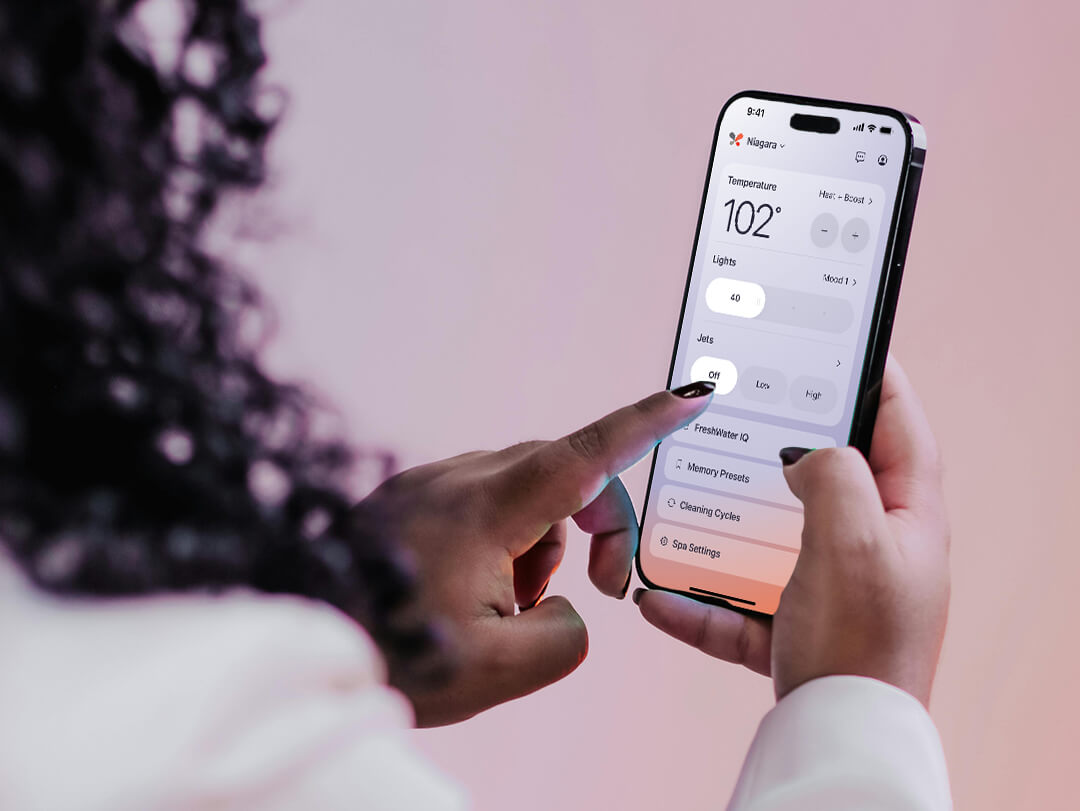Woman using the Caldera Spas app from the convenience of her phone.